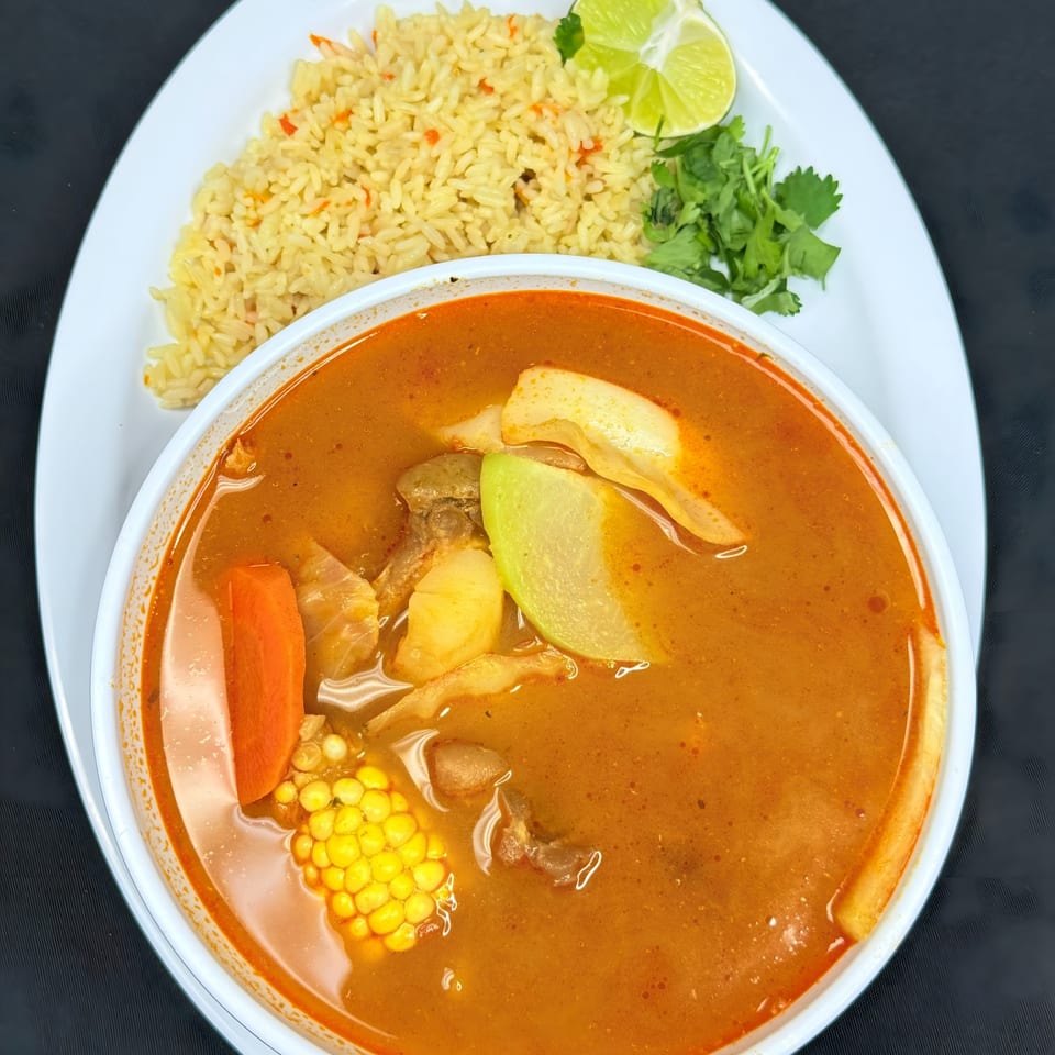 Mi Casita Restaurant's Mexican soup with corn, carrots, and other vegetables, served with rice and lime.