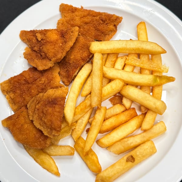 A white plate holds golden-brown breaded chicken cutlets and a pile of crispy french fries.
