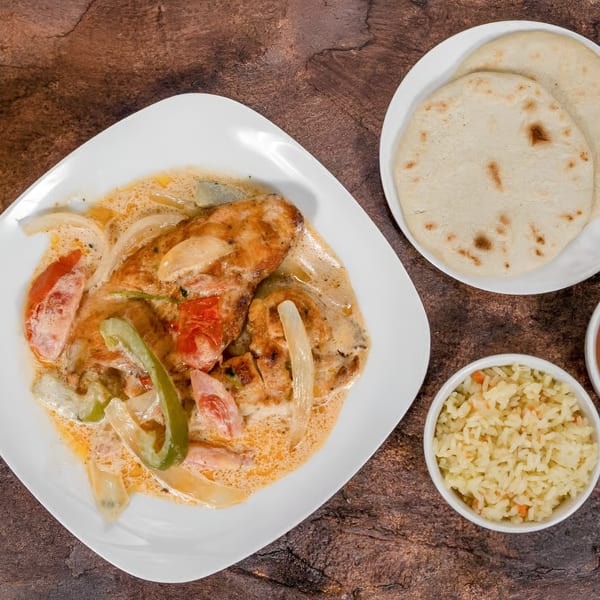 Mi Casita Restaurant's creamy chicken dish with bell peppers and onions, served with rice and tortillas.