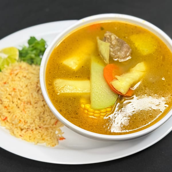 Hearty Mexican soup with beef, corn, chayote, carrots, and potatoes, served with rice and lime.