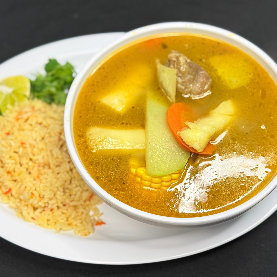Hearty Mexican soup with beef, corn, chayote, carrots, and potatoes, served with rice and lime.