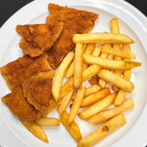 A white plate holds several pieces of golden-brown breaded chicken cutlets and a pile of french fries.