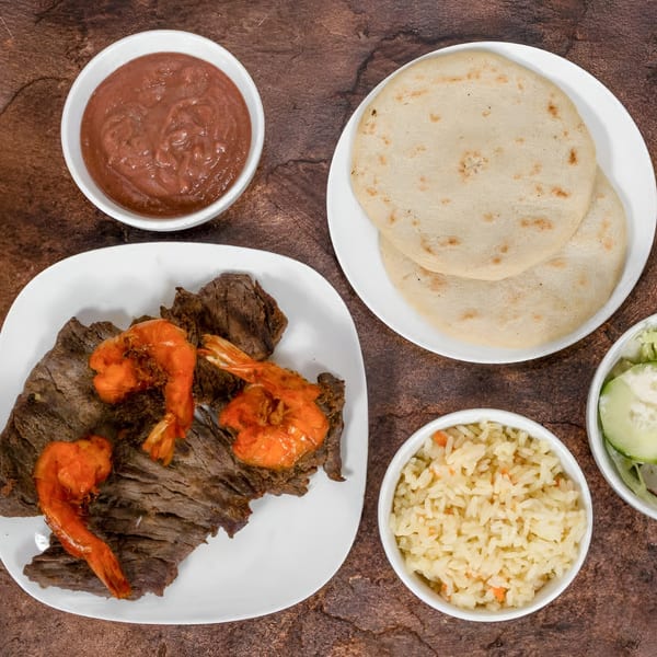 Mi Casita's carne asada with shrimp, rice, tortillas, refried beans, and a side salad.