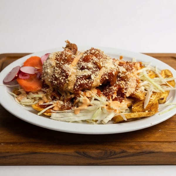 Mi Casita Restaurant's Mexican dish with fried plantains, shredded cabbage, sauce, and cheese.