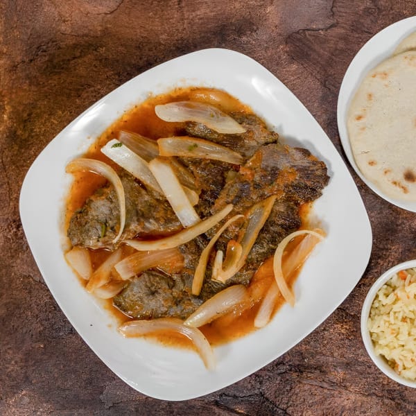 Mi Casita's carne asada with onions and sauce, served with tortillas and rice.