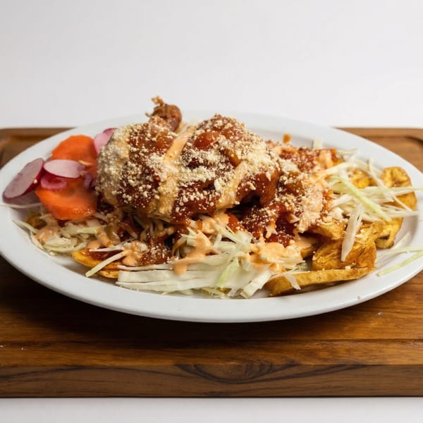 Mi Casita's Mexican dish with fried plantains, shredded cabbage, sauce, and crumbled cheese.